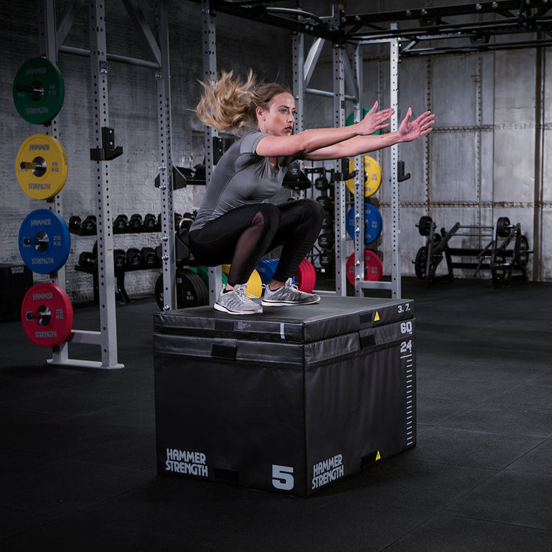 Female jumping on stacked Hammer Strength Plyo Box in gym