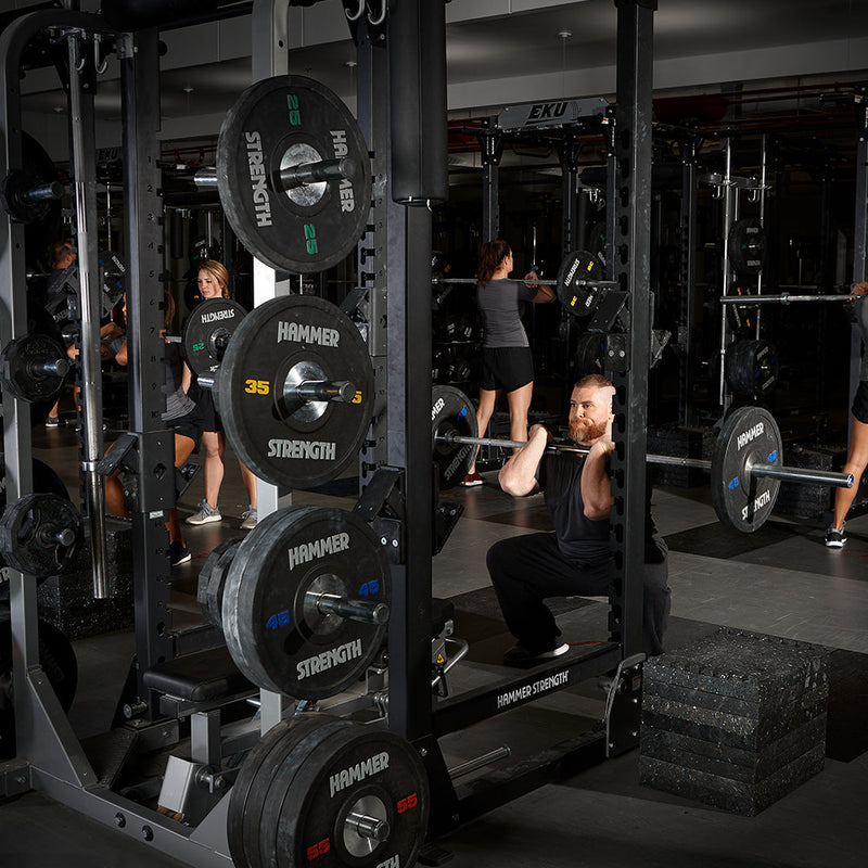 man front squatting with black urethane plates