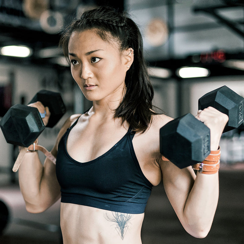 Female bicep curling with hex dumbbell