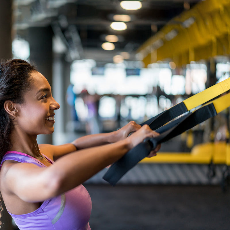 Exerciser using TRX in gym